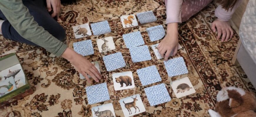 Children playing a matching-pairs game with animal cards