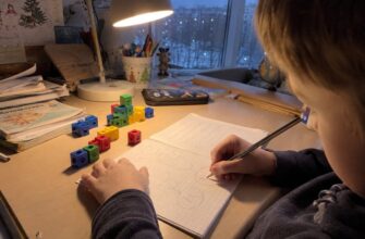 A child drawing a word-problem diagram under a desk lamp