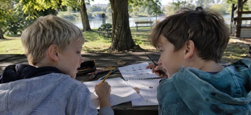 Children creating symbol codes at a park table