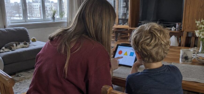 A parent and child discussing a tablet activity